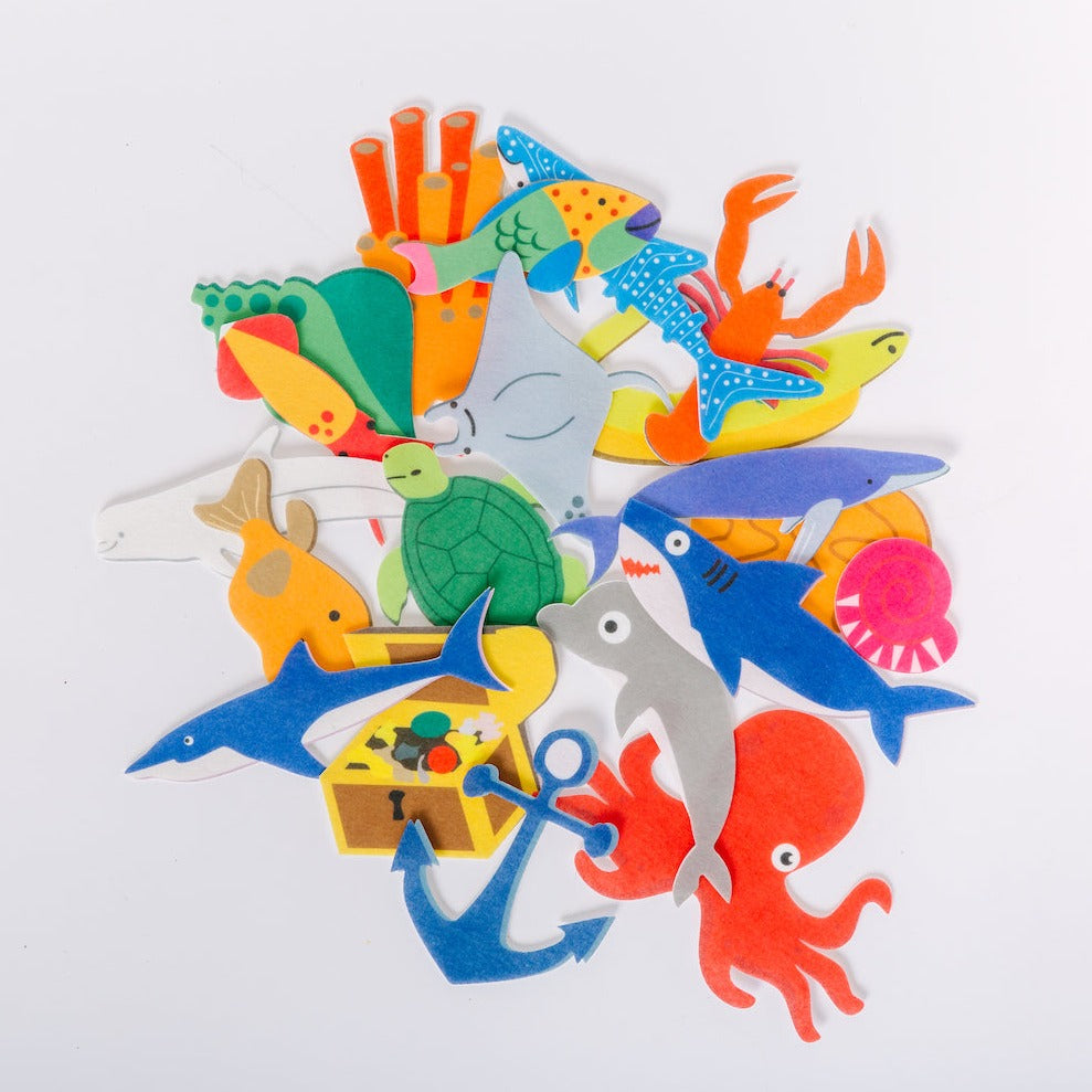 A collection of colorful felt ocean animals and objects, including a whale, turtle, and various sea creatures, displayed on a white background.
