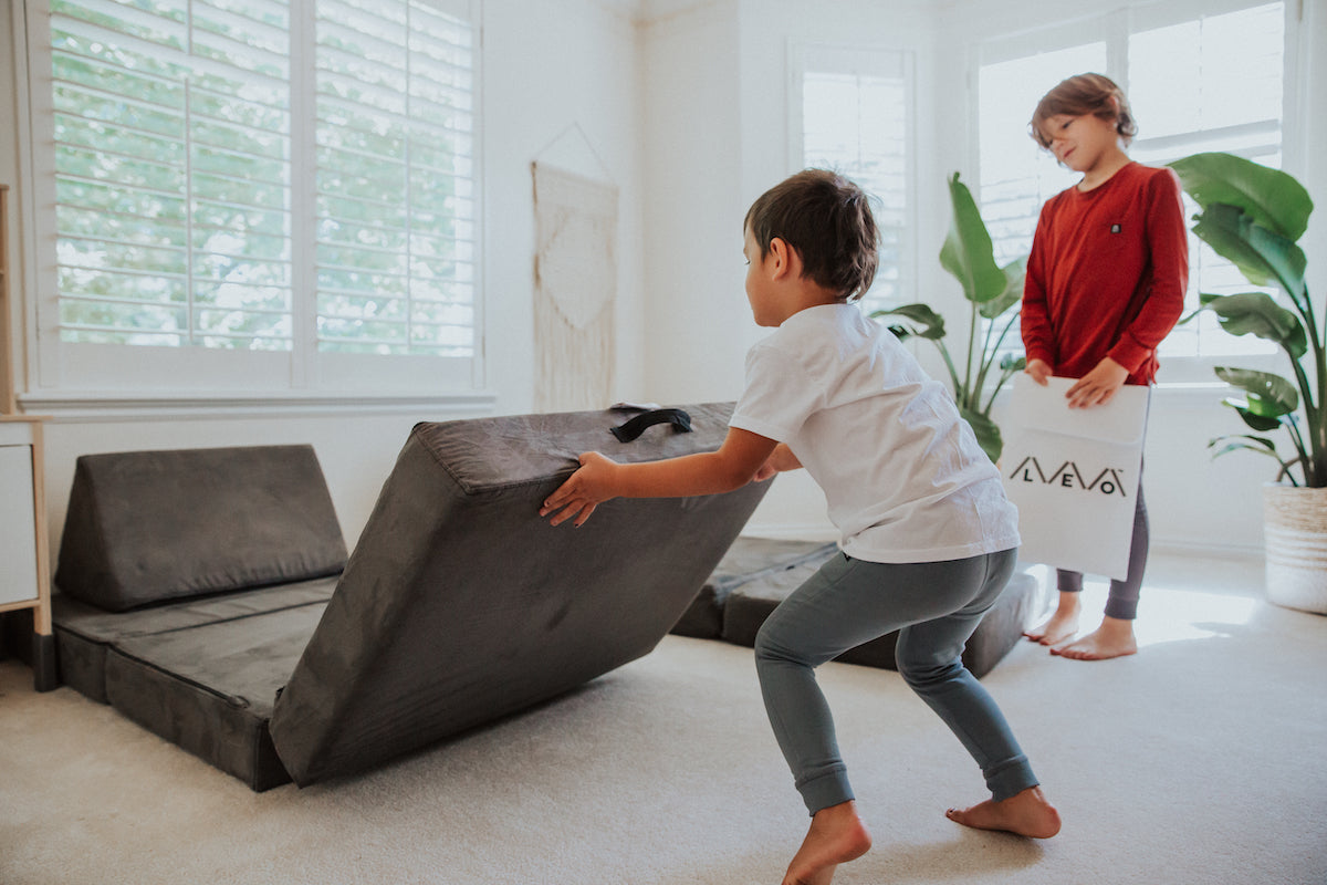 Child playing on foam play sofa with a friend
